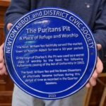 Blue Newton Abbot & District Civic Society plaque for the Puritans’ Pit, held in front of the camera