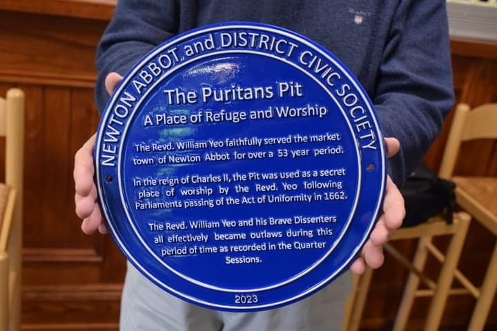 Blue Newton Abbot & District Civic Society plaque for the Puritans’ Pit, held in front of the camera